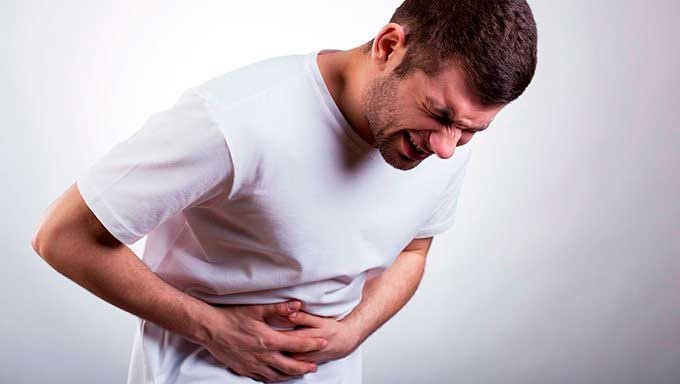 a man clutching stomach due to gall bladder pain